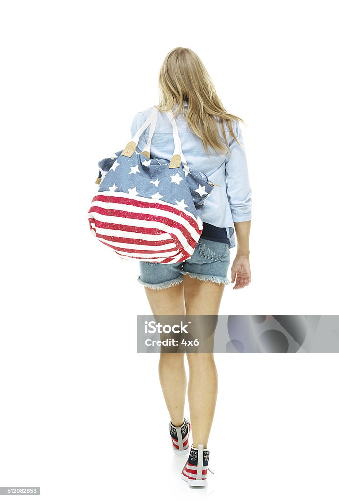 Rear view of woman holding purse & walking Rear view of woman holding purse & walkinghttp://www.twodozendesign.info/i/1.png 20-29 Years Stock Photo