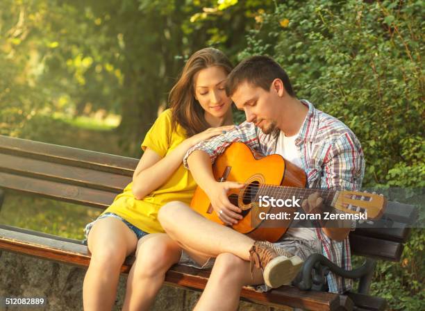 Young Couple Playing Guitar At The Park Stock Photo - Download Image Now - 20-24 Years, 30-34 Years, Acoustic Guitar