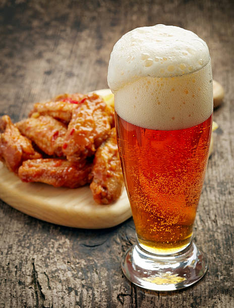 verre de bière fraîche et des ailes de poulet frit - wing beer spicy chicken wings chicken wing photos et images de collection