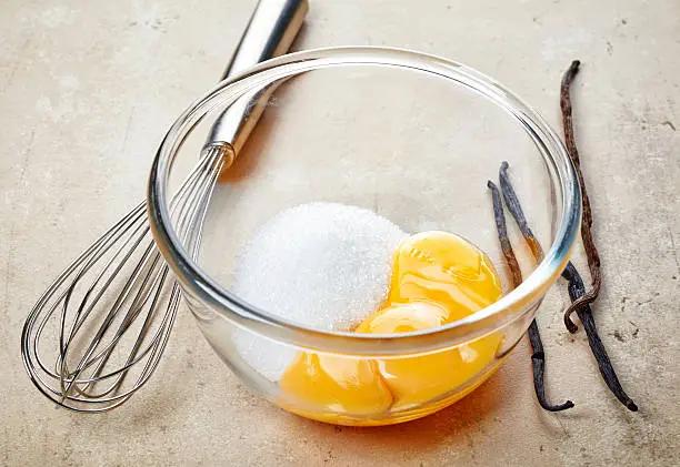 egg yolks and sugar in a glass bowl