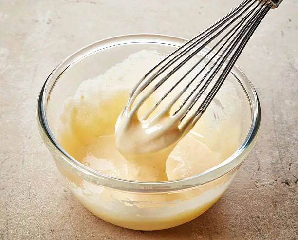 whipped egg yolks with sugar in a glass bowl