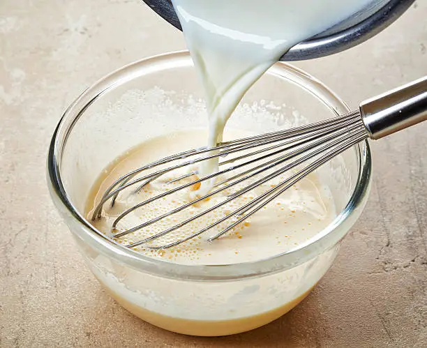 making vanilla sauce in a glass bowl with whipper