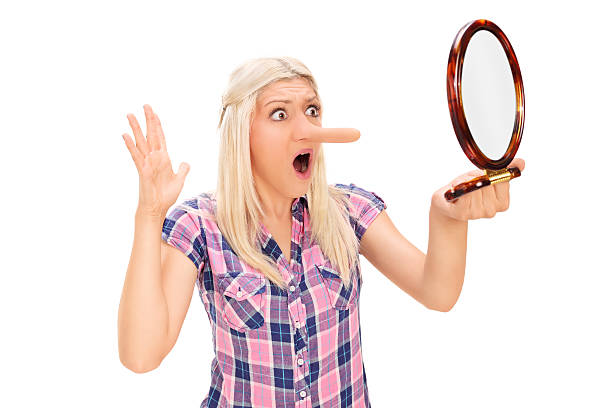istock Shocked woman looking at her long nose in a mirror 512084841