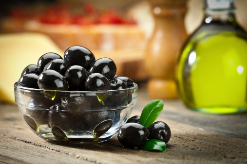 Black olives on wooden table