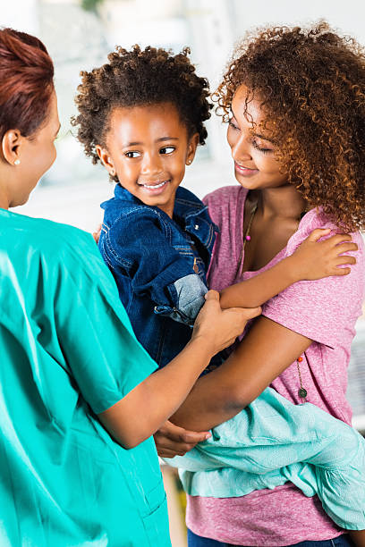 istock Cute Ethiopian child smiling at doctor during check up exam 512085279