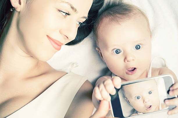 istock Funny baby and mother make selfie on mobile phone 512094334