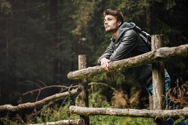 giovane uomo escursioni nella foresta - lonely tree immagine foto e immagini stock
