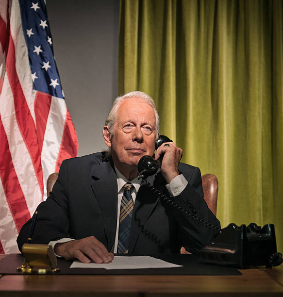 istock Big boss president calling behind desk with american flag. 512099105