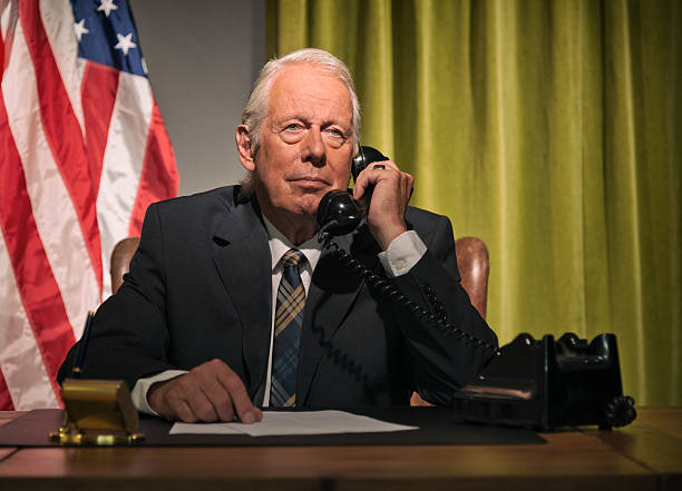 istock Big boss president calling behind desk with american flag. 512099117