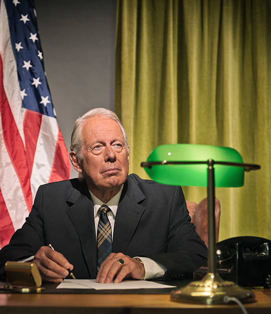 istock Big boss president writing behind desk with american flag. 512099147