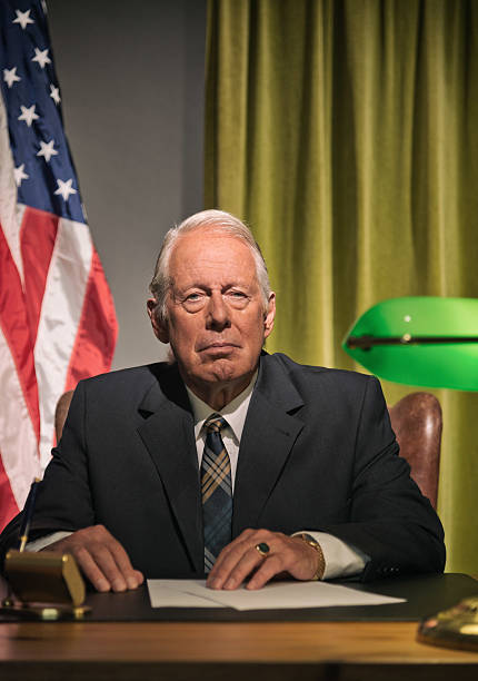 istock Big boss president sitting behind desk with american flag. 512099155