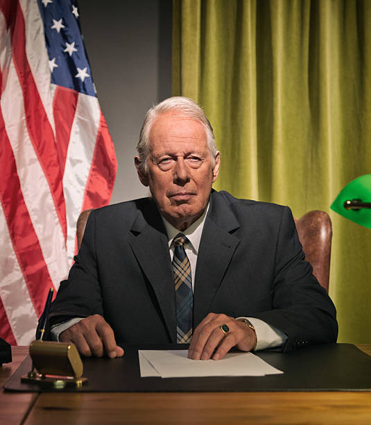 istock Big boss president sitting behind desk with american flag. 512099157