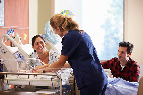 Family And Nurse With New Born Baby In Post Natal Family And Nurse With New Born Baby In Post Natal Department maternity ward stock pictures, royalty-free photos & images