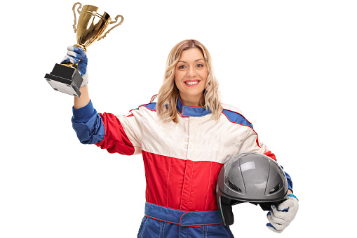 Female car racing champion holding a trophy and looking at the camera isolated on white background