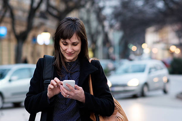 istock Brunette woman using smart phone in city 512101122