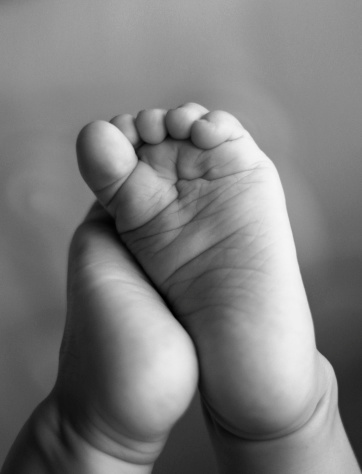 Newborn baby girl being supported by her mother and father