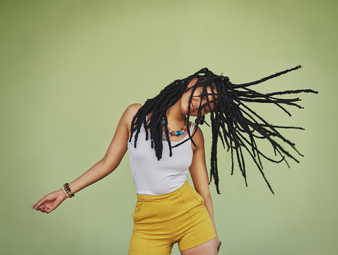 A closeup shot of a teenager's dreadlocks hairstyle from a back view