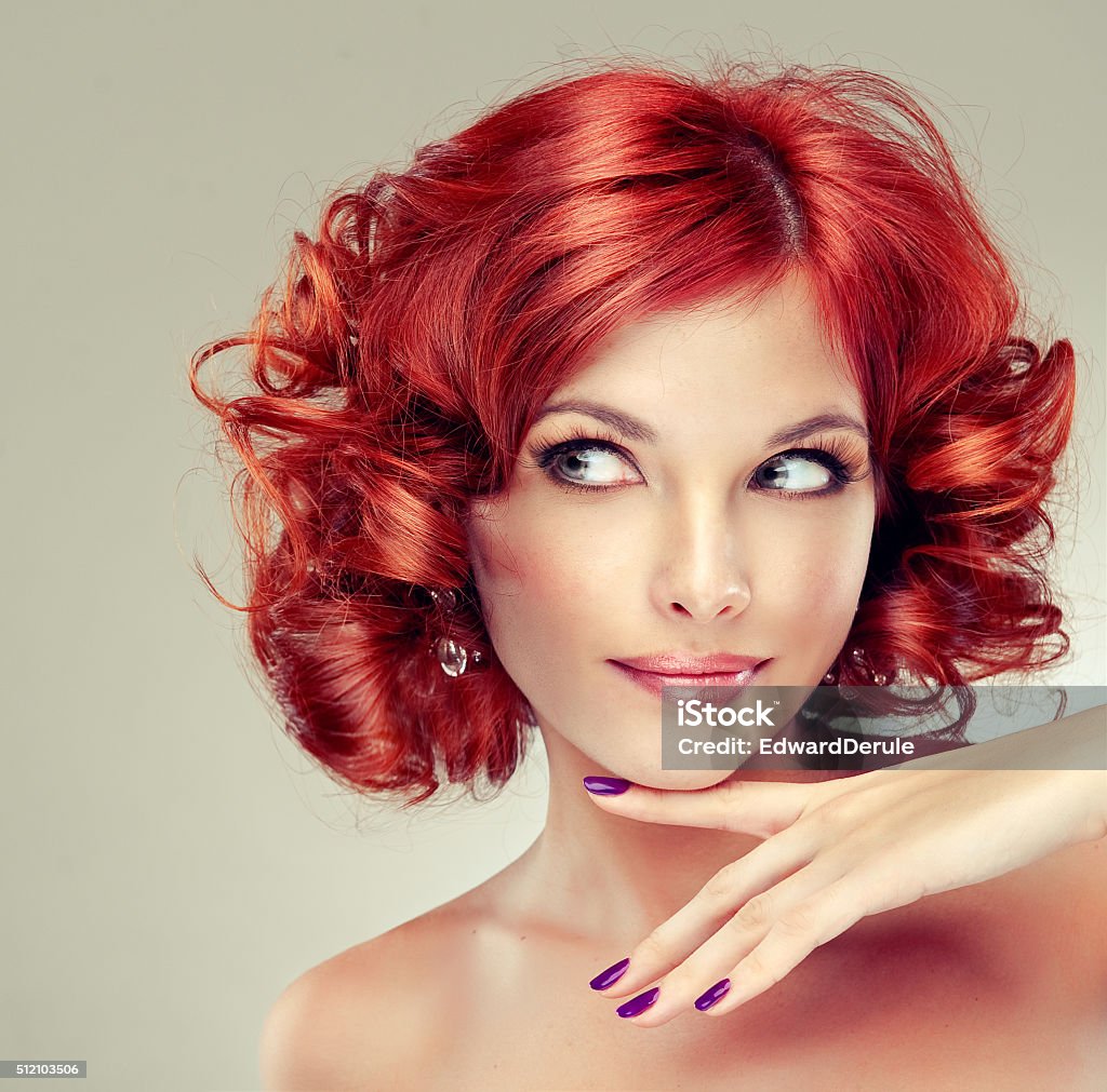 Girl model with curly red hair. Trendy image red head woman. Pretty red haired girl with curls , fashionable makeup and pink manicure. Tricky glance.   Beautiful People Stock Photo