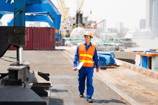 Dock worker walking around cargo port
