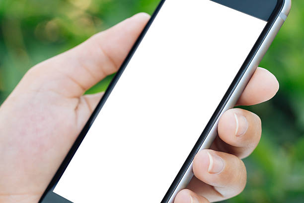 istock Closeup hand holding phone white screen outdoor 512104810