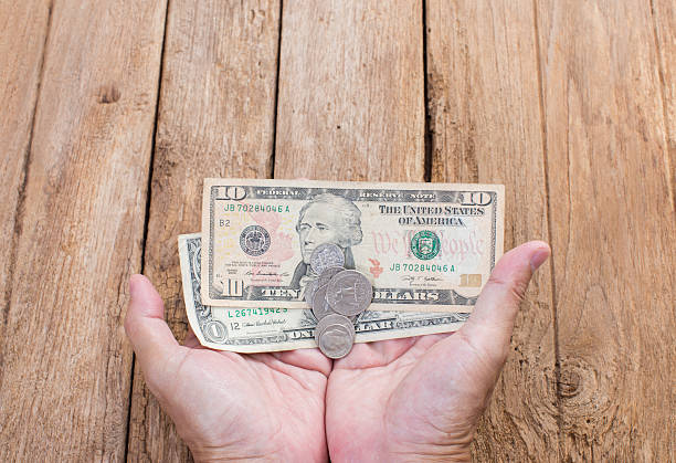 istock Dollar money on hands with wooden background 512104973