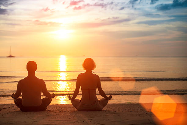 istock Silhouette of young couple practicing yoga 512105103