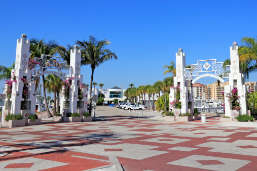 Sarasota, Florida, USA - May 9, 2013: A couple of very beautiful entrances to Sarasota Bay front that are mostly white, ornate, growing purple bougainvillea flowers and other foliage and palm trees.