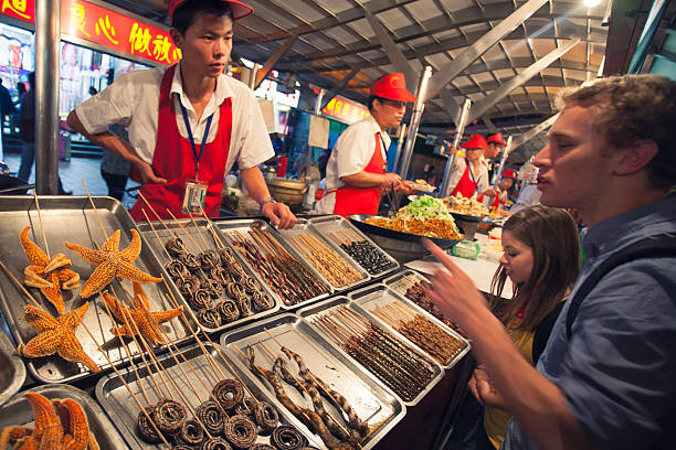 Beijing, China - August 26, 2014: In a Wangfujing side street there are many stalls offering street food, from common chinese cuisine to  exotic foods like sea stars, snakes and various insects.