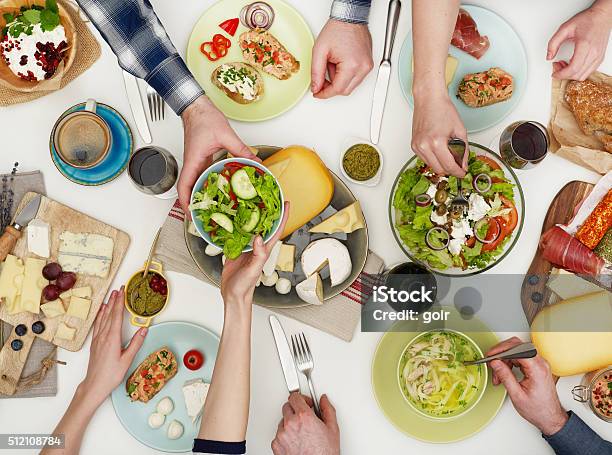 View From Above The Table Of People Eating Stock Photo - Download Image Now - Sharing, Food, Dining Table