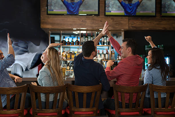 grupo de amigos viendo un partido de fútbol en el pub - sport watching television broadcasting television fotografías e imágenes de stock