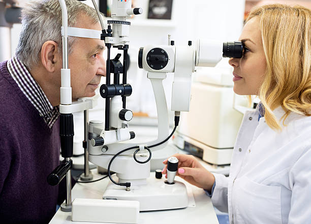 istock Female ophthalmic doctor check eyes to elderly man 512119538