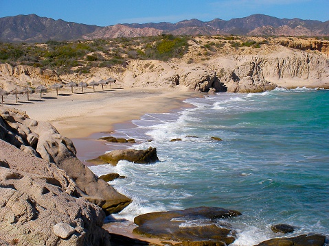 Secluded sandy beach in Cabo Pulmo National Marine Park. With mountains, rocks and pacific ocean. Cabo Pulmo is a national marine park on the east coast of Mexico's Baja California Peninsula