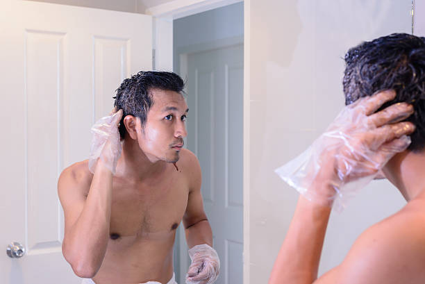 istock Man cleaning after hair coloring by oneself with a mirror. 512121450