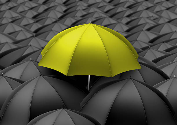 istock Yellow umbrella above black umbrellas 512121844