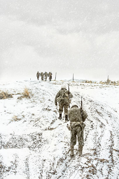 Battle Weary WWII US Squadron Walking Up A Muddy Hill