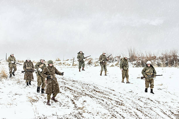 istock Battle Weary WWII US Squadron Walking Down A Muddy Road 512122728