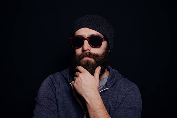 atractivo hombre grandes barba en gafas y sombrero - male studio shot looking at camera lifestyles fotografías e imágenes de stock