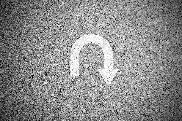 White u turn sign on asphalt concret street as background