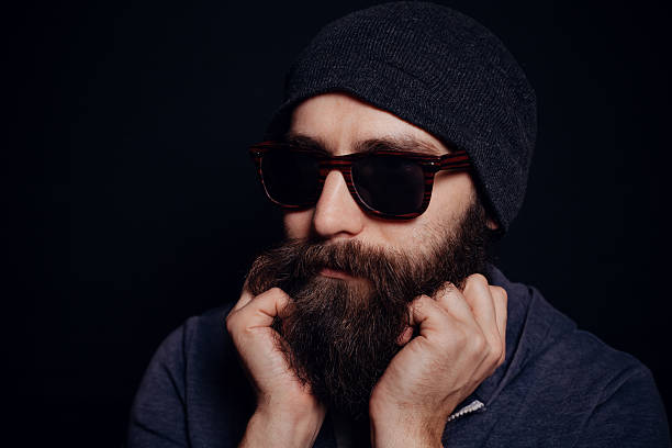 atractivo hombre grandes barba en gafas y sombrero - male studio shot looking at camera lifestyles fotografías e imágenes de stock