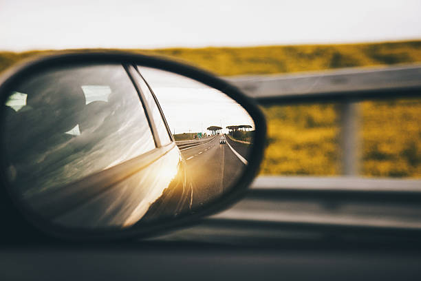 carro na estrada ao pôr do sol - rear view mirror car mirror sun - fotografias e filmes do acervo