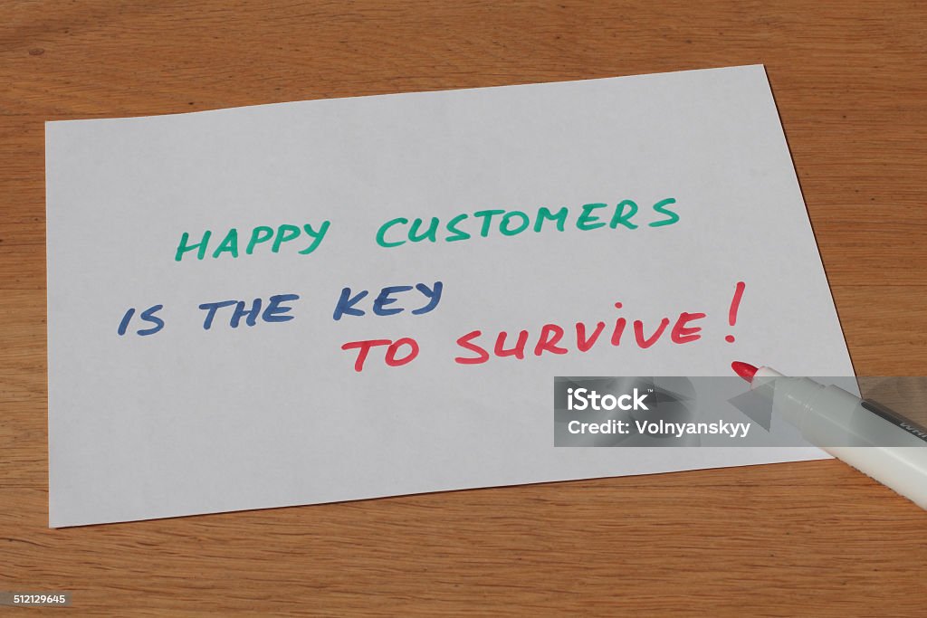 Business note about happy customers is the key to survive Business note about happy customers is the key to survive handwritten on the white paper with pen Blue Stock Photo