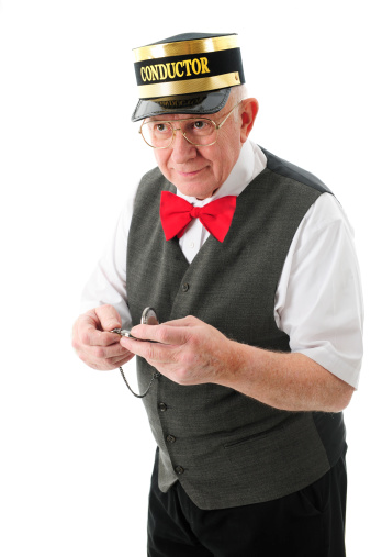 A senior adult conductor holding his pocket watch and looking pleased that the train is coming right on time.  On a white background.