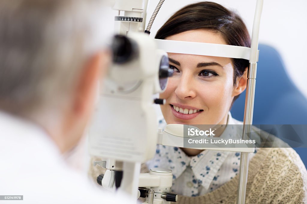 Woman look in ophthalmoscope Dark hear woman look in ophthalmoscope to determine diopter in clinic Eye Stock Photo