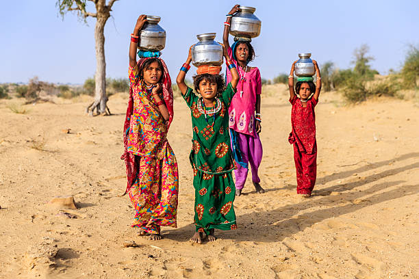 indische mädchen tragen von wasser auf den kopf gut - poverty india child little girls stock-fotos und bilder