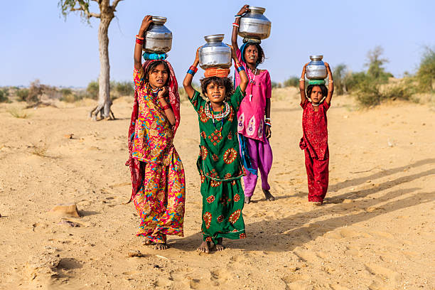 indian petite fille portant sur la surface de l'eau de bien - thar desert photos et images de collection