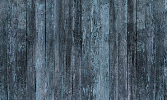 An abstract background of a rustic old weathered woodgrain fence with blue and black and gray tones.