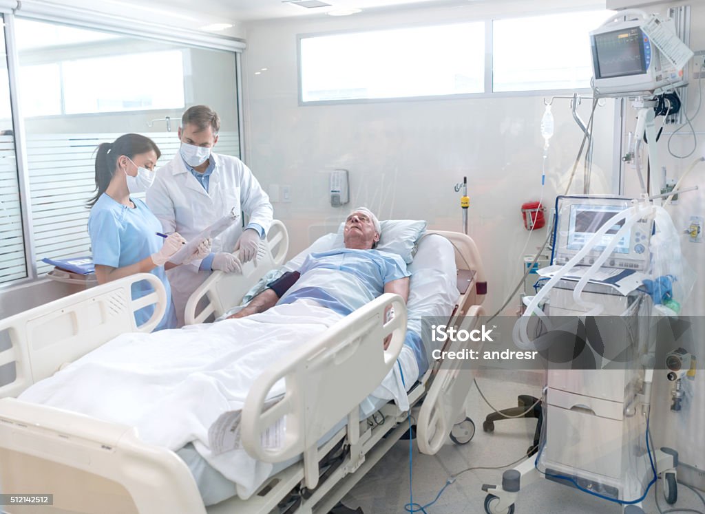 Doctors working at the hospital Doctors working at the hospital and checking on a senior patient at the Intensive Care Unit - healthcare and medicine concepts Intensive Care Unit Stock Photo
