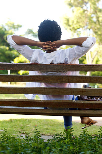 istock Relaxed young woman sitting on a park bench 512142698
