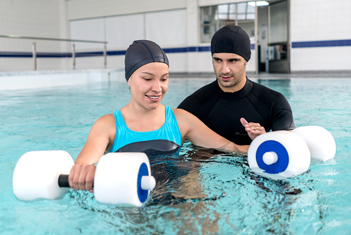 Young woman doing physical therapy in the water - healthcare and medicine