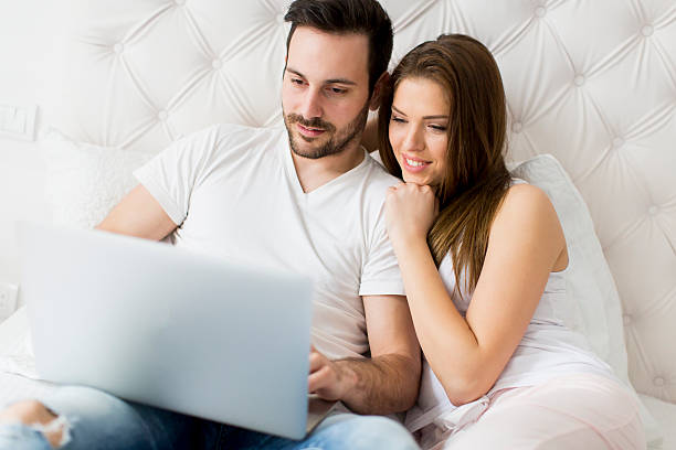 istock Young couple with laptop in the bed 512144352